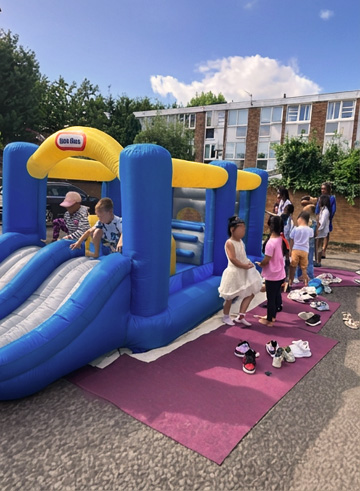 Children at the outdoor bouncy castle on a Cornerstone family fun day (faces blurred)