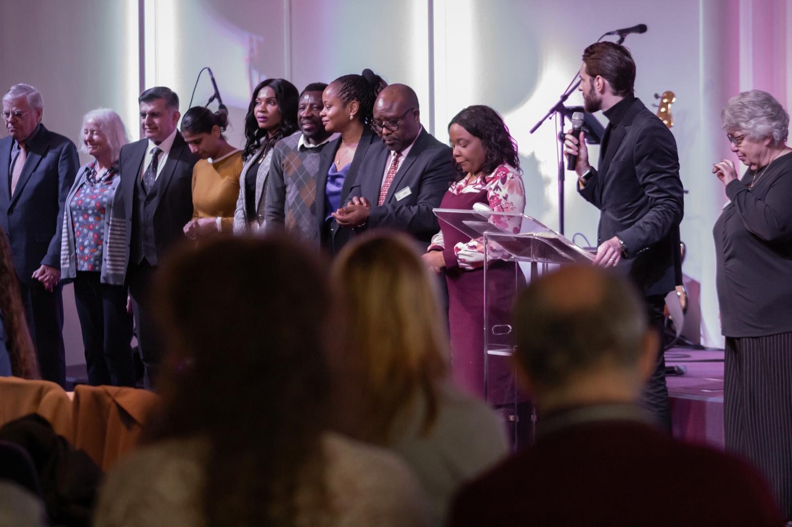 Ministry leaders lined up on stage in prayer