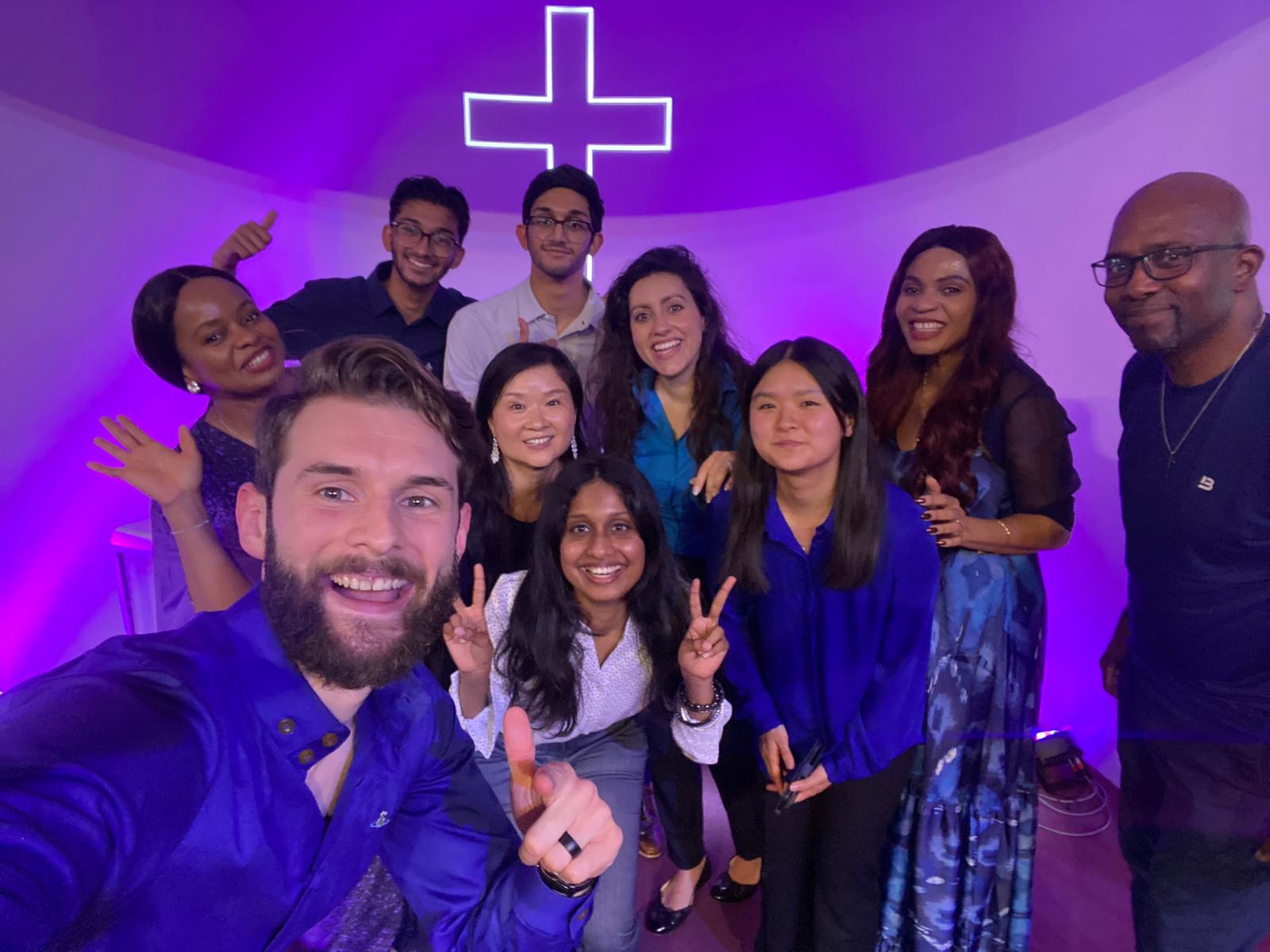The worship team gathered for a group photo on stage in front of the cross
