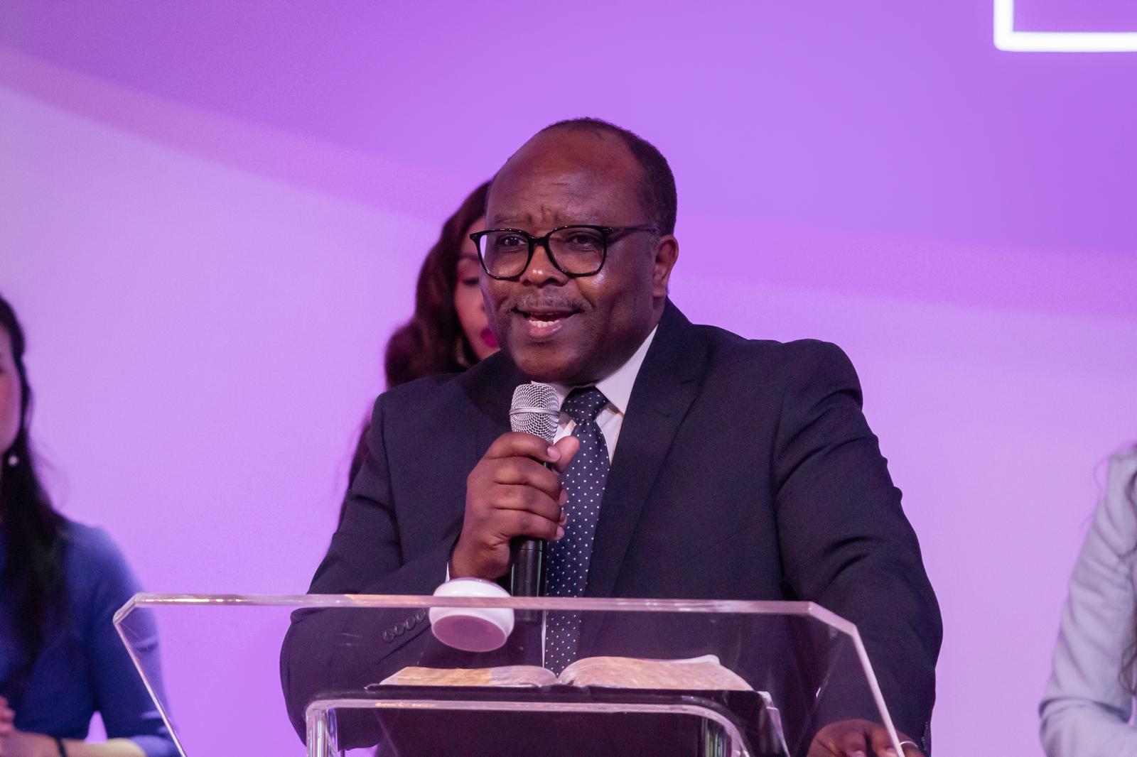 Samson Buwu preaching at the lectern at Cornerstone