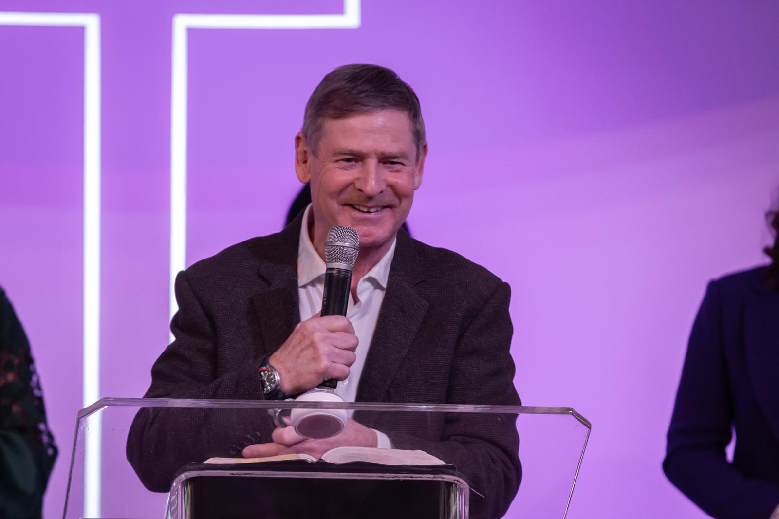 Pastor Rob Andrews smiling at the lectern at Cornerstone