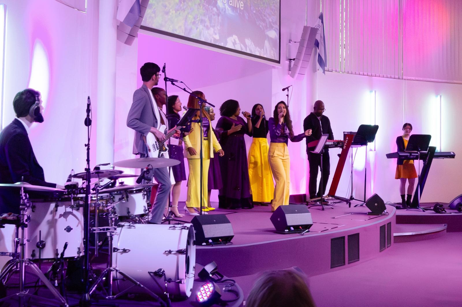 The worship band with backing singers in yellow dresses