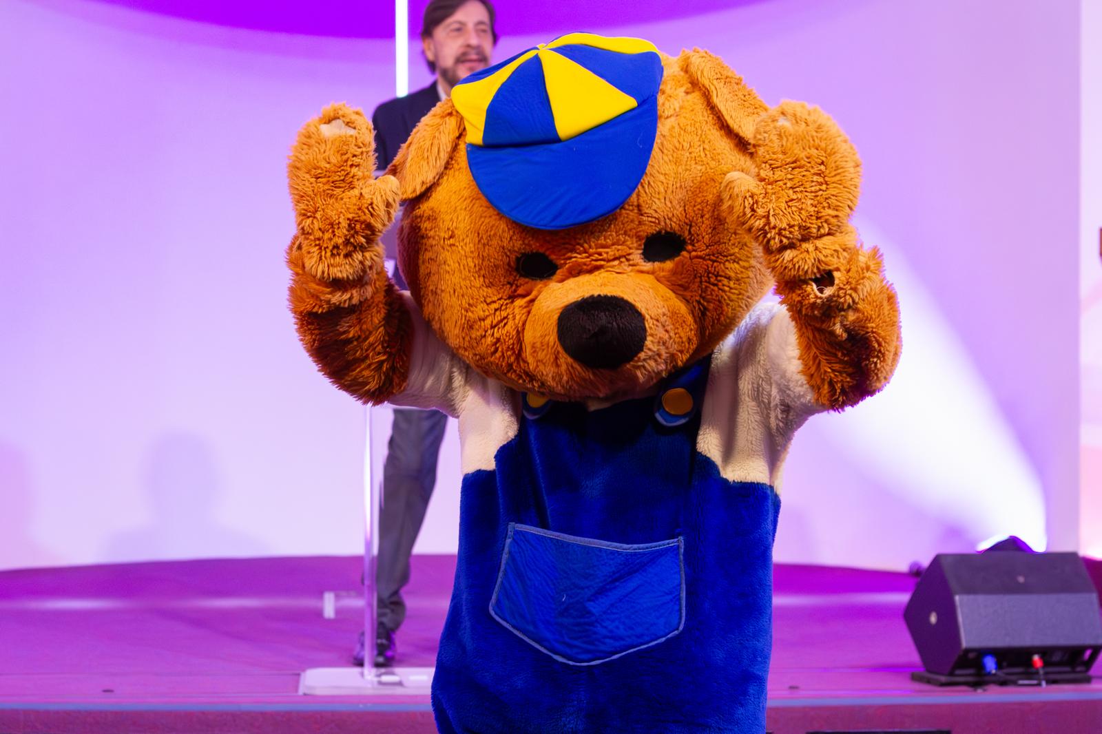 Godfrey the KidZone bear mascot on stage