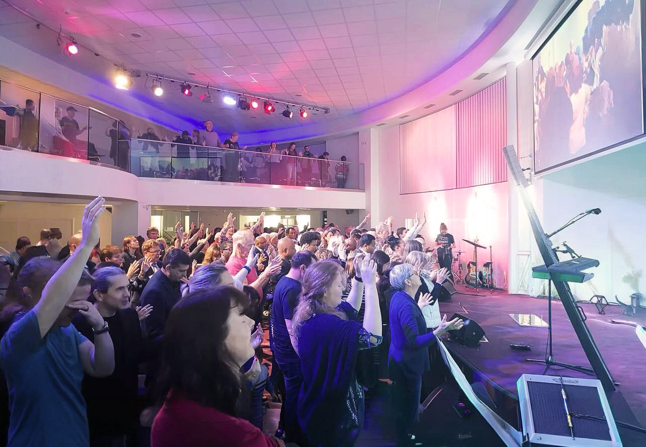 A full Sunday service at Cornerstone with the congregation worshipping, hands raised