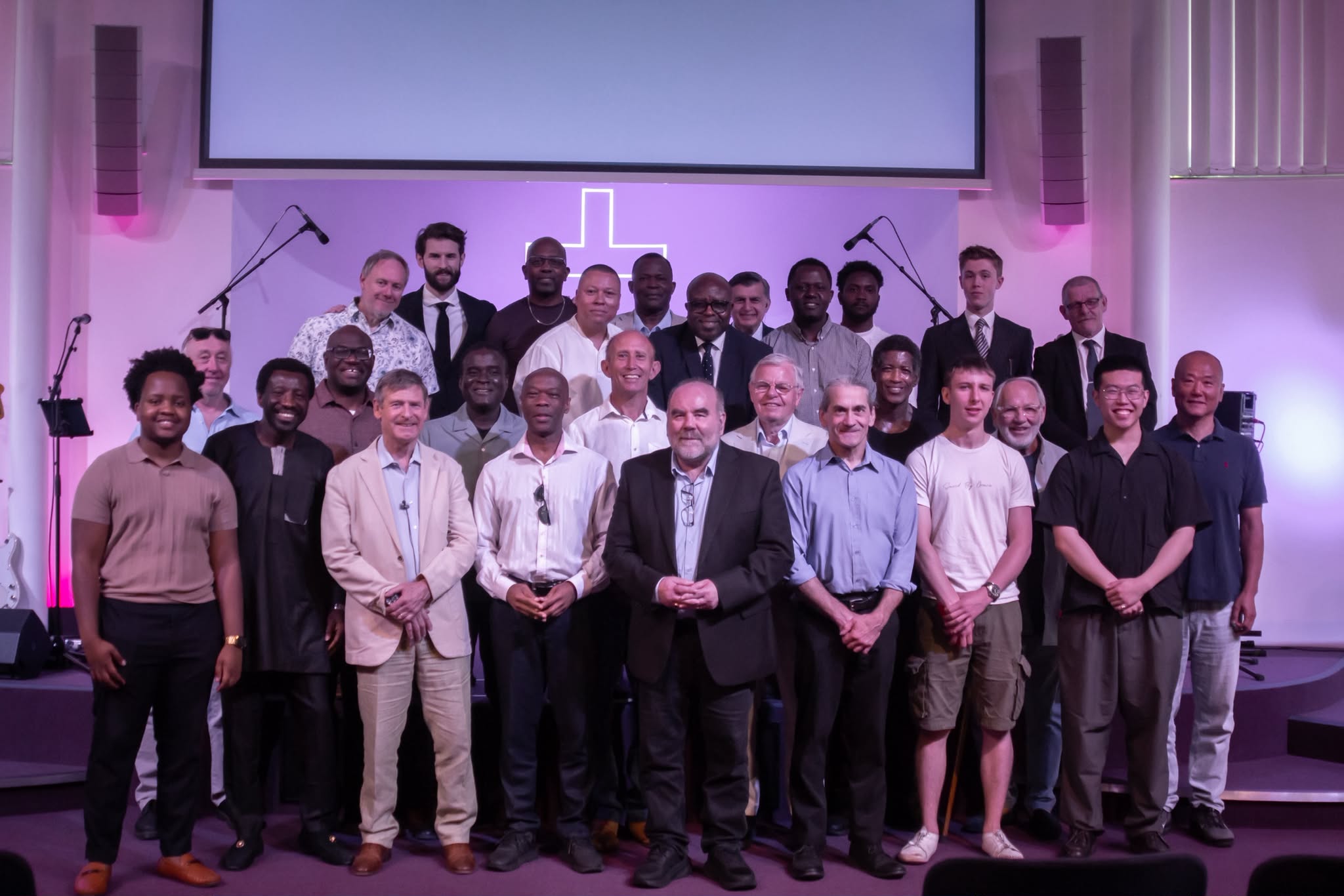 The men of Cornerstone gathered together on stage in front of the cross