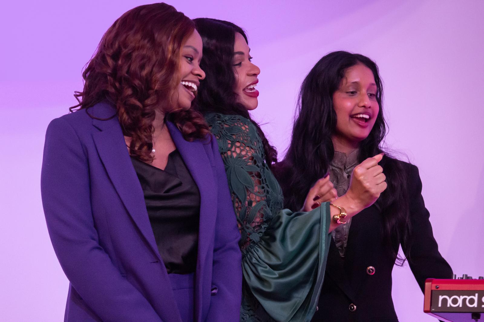 Three women on stage singing in a worship set